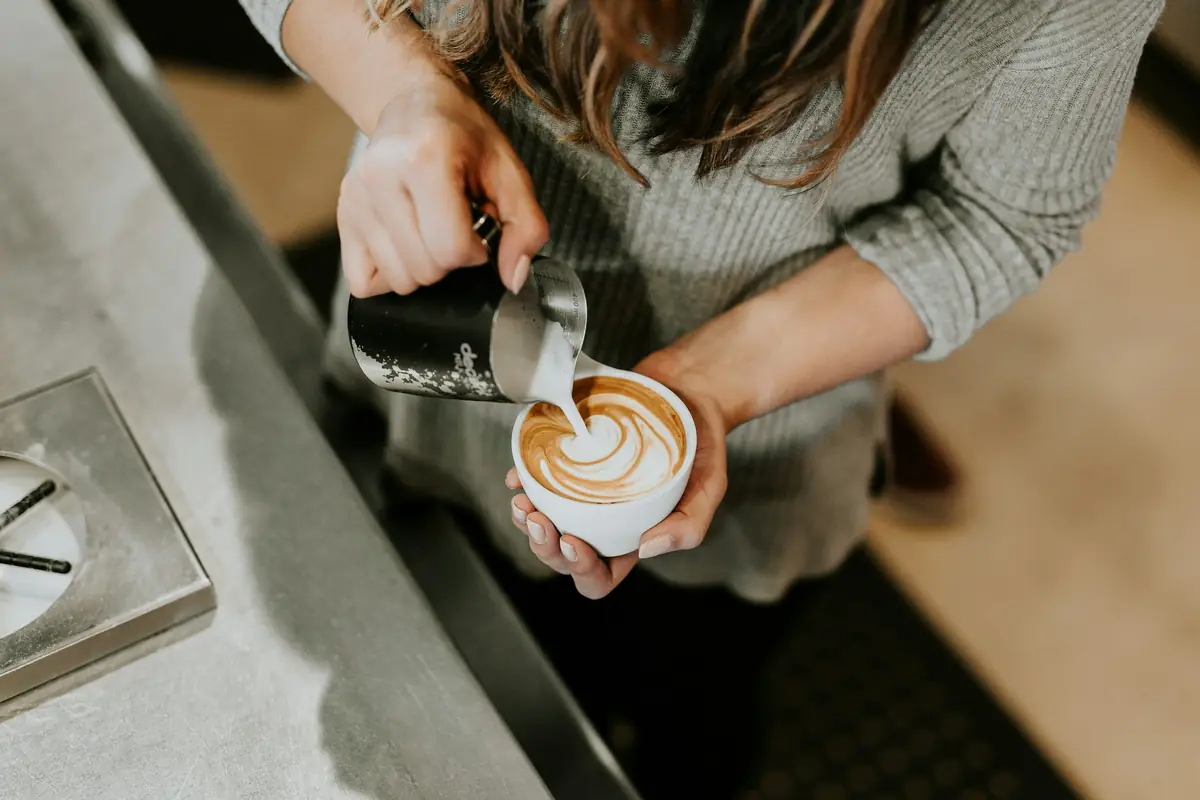 Barista menuang latte